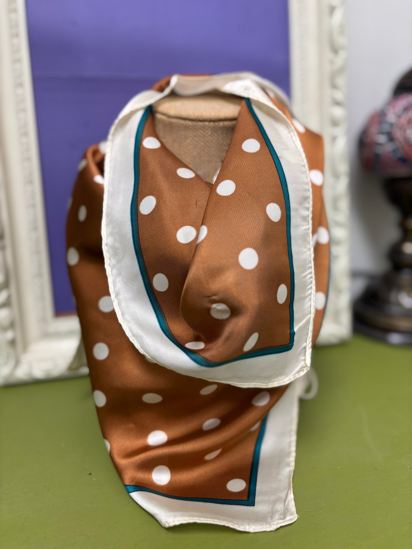 Brown fabric with white polka dots on a green surface